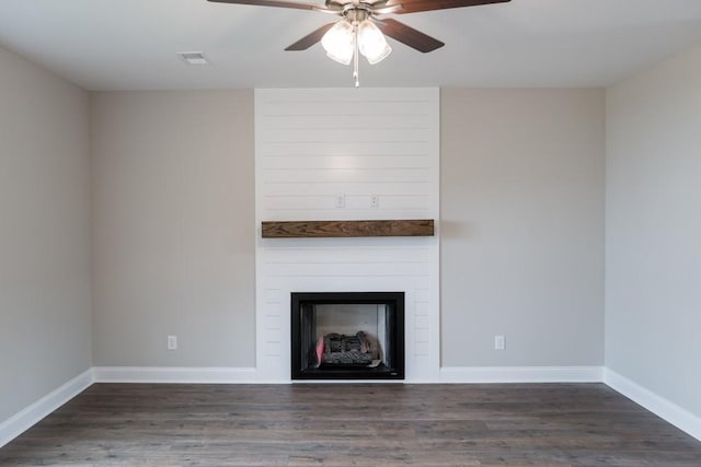 unfurnished living room featuring ceiling fan, a fireplace, and dark wood-type flooring