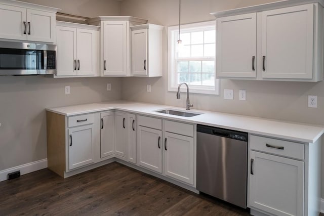 kitchen with dark hardwood / wood-style flooring, stainless steel appliances, white cabinetry, and sink