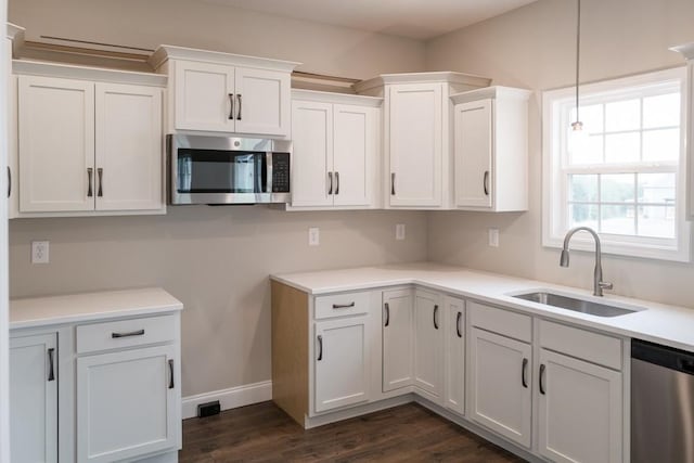 kitchen with dark hardwood / wood-style flooring, sink, white cabinets, and appliances with stainless steel finishes