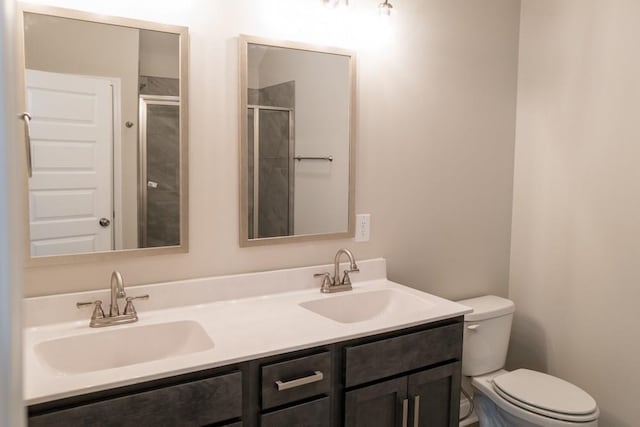 bathroom featuring vanity, toilet, and a shower with door