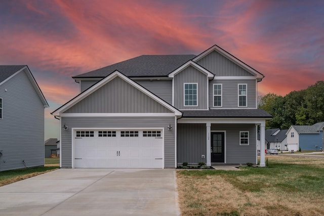 craftsman inspired home featuring a garage, covered porch, and a yard