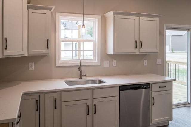 kitchen with sink, hardwood / wood-style flooring, dishwasher, white cabinetry, and hanging light fixtures