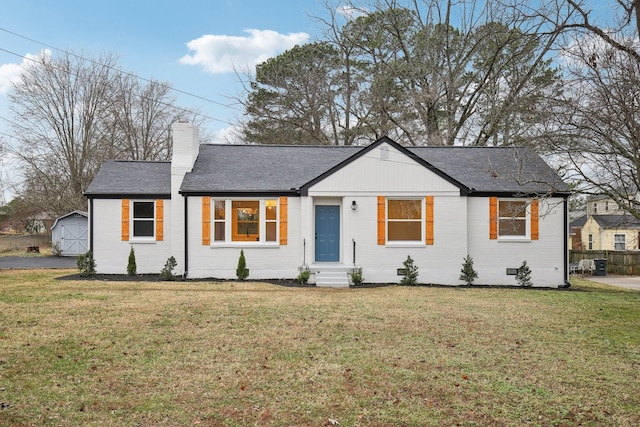 view of front facade featuring a shed and a front lawn