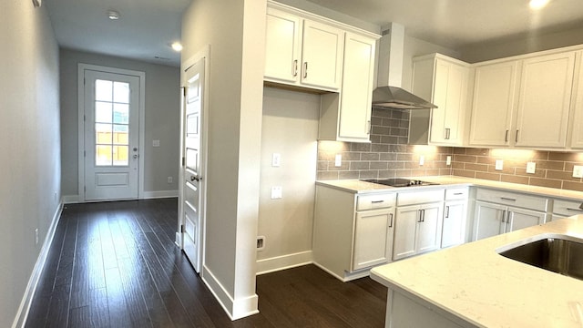 kitchen with white cabinets, wall chimney exhaust hood, dark hardwood / wood-style flooring, and tasteful backsplash