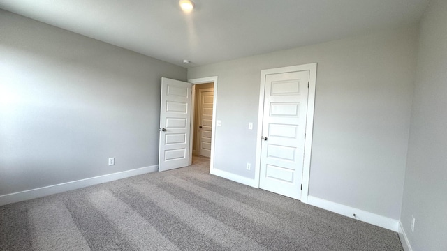 unfurnished bedroom featuring carpet flooring and a closet