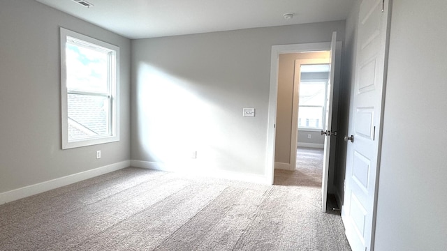 unfurnished room featuring plenty of natural light and carpet floors