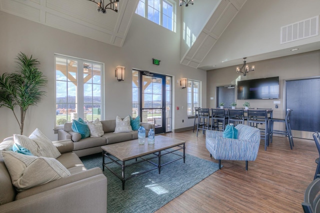 living room featuring hardwood / wood-style flooring, a high ceiling, and a notable chandelier