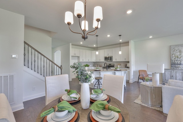 dining space with dark hardwood / wood-style flooring and an inviting chandelier