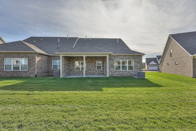 rear view of house with a yard, a patio, and central AC