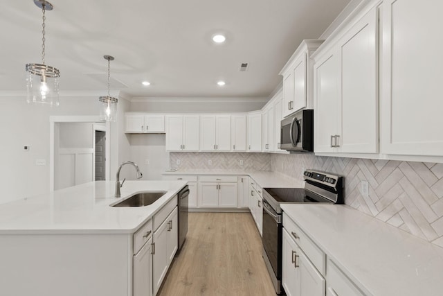 kitchen with hanging light fixtures, stainless steel appliances, sink, and white cabinets