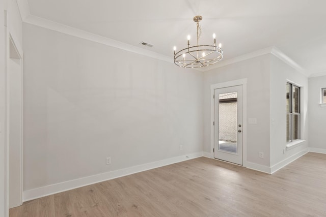 unfurnished room featuring ornamental molding, plenty of natural light, an inviting chandelier, and light wood-type flooring