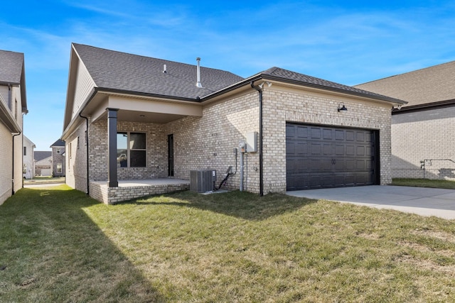 exterior space featuring a garage, a yard, and central AC