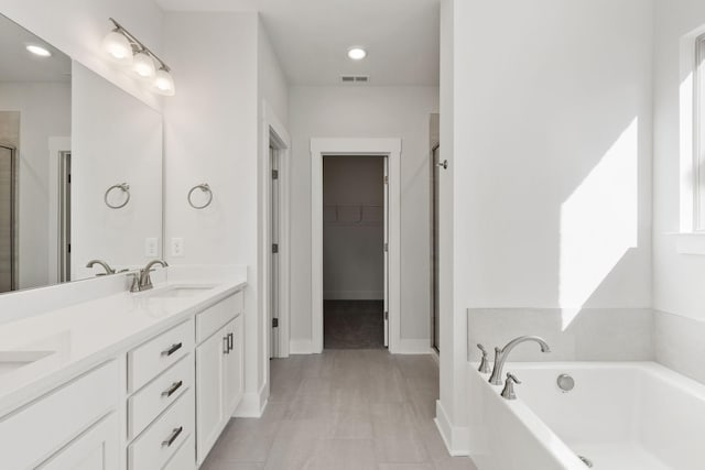 bathroom featuring vanity and independent shower and bath