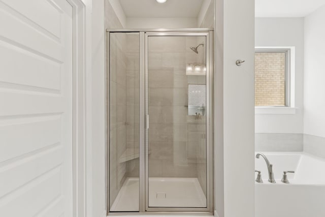 bathroom featuring shower with separate bathtub