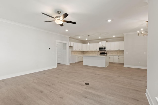 kitchen with white cabinetry, stainless steel appliances, a center island with sink, and pendant lighting