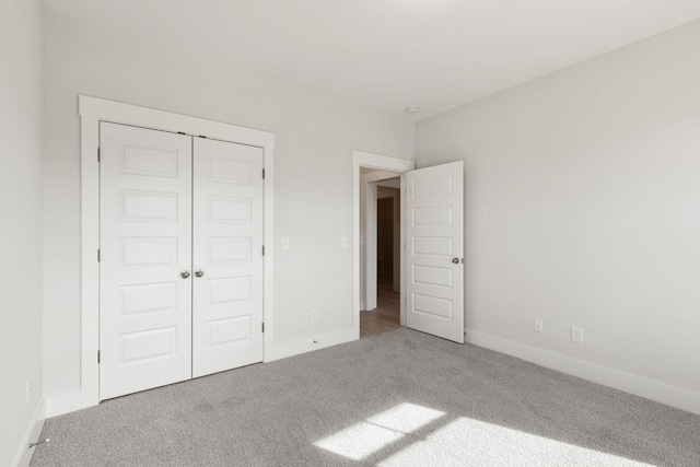 unfurnished bedroom featuring carpet flooring and a closet