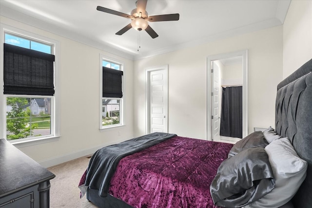 bedroom featuring ceiling fan, carpet flooring, ornamental molding, and ensuite bath