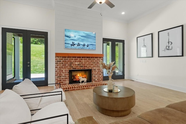 living room with a healthy amount of sunlight, french doors, a fireplace, and light hardwood / wood-style floors