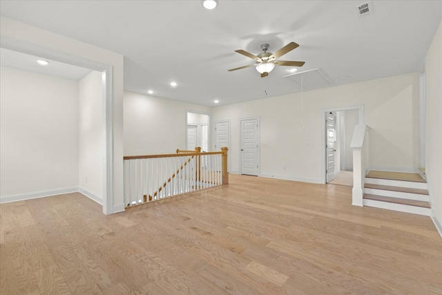 empty room with ceiling fan and light hardwood / wood-style floors