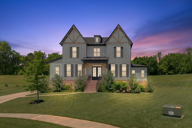 view of front of house with a lawn and french doors