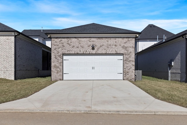 view of front of home with central AC, a garage, and a front yard