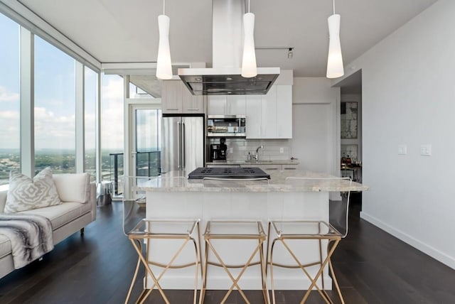 kitchen featuring white cabinets, stainless steel appliances, light stone countertops, and decorative light fixtures