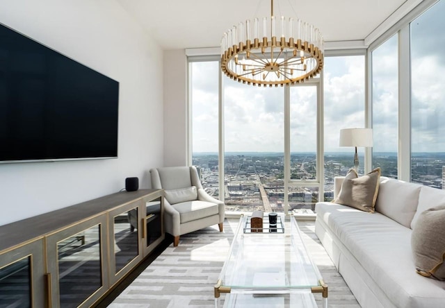 living room featuring an inviting chandelier and a wall of windows