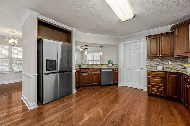 kitchen with crown molding, appliances with stainless steel finishes, dark hardwood / wood-style flooring, and light stone countertops