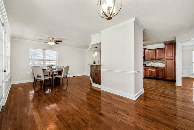 dining space featuring dark hardwood / wood-style flooring, ceiling fan with notable chandelier, and ornamental molding