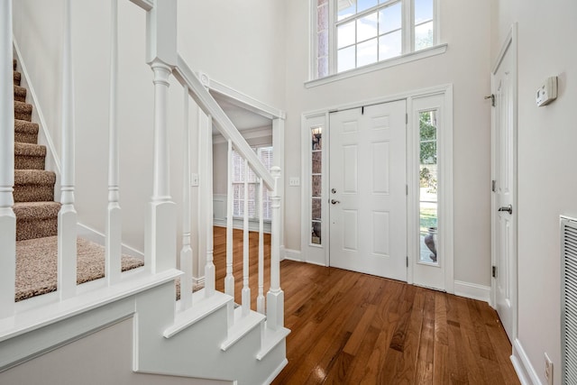 entryway featuring hardwood / wood-style flooring and a towering ceiling