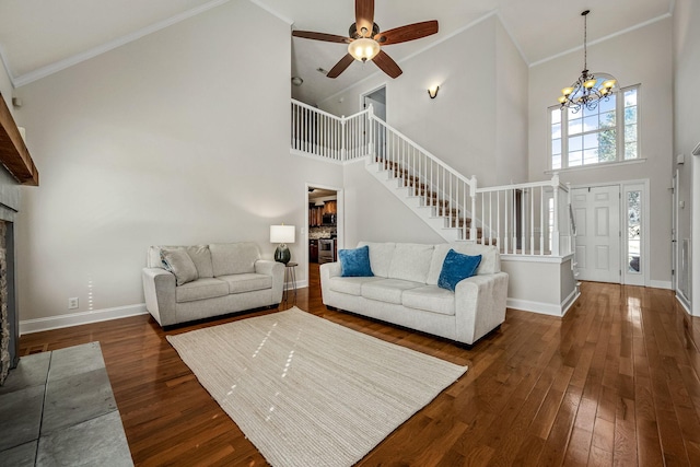 unfurnished living room with a fireplace, dark hardwood / wood-style flooring, a high ceiling, crown molding, and plenty of natural light