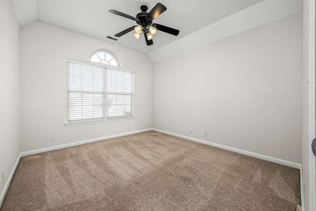 carpeted empty room with ceiling fan and vaulted ceiling