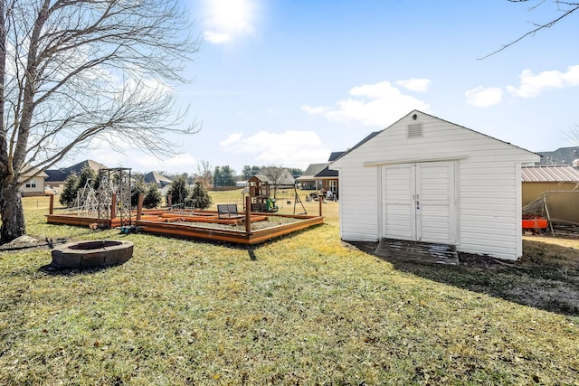 view of yard featuring an outdoor fire pit and a storage unit