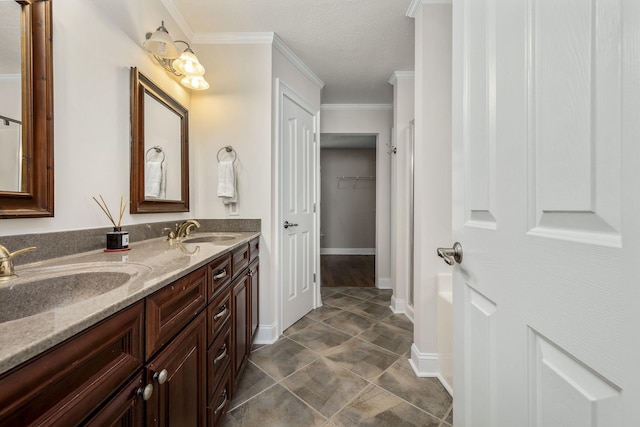 bathroom featuring crown molding, vanity, and a textured ceiling