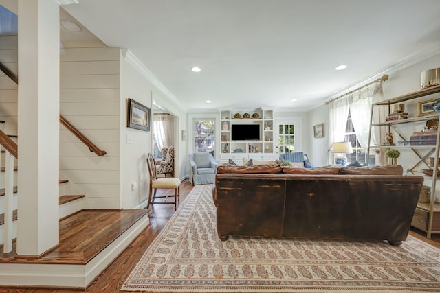 living room featuring wood-type flooring, plenty of natural light, and ornamental molding