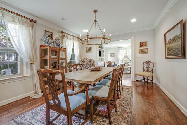 dining space featuring dark hardwood / wood-style floors, an inviting chandelier, and crown molding