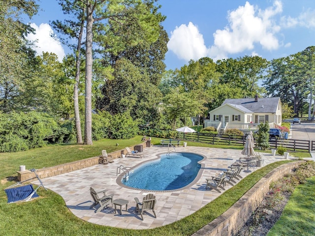 view of swimming pool featuring a patio and a lawn