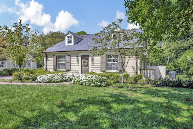 cape cod house featuring a front lawn