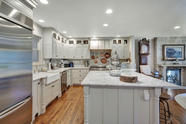 kitchen featuring white cabinets, a kitchen breakfast bar, sink, a kitchen island, and stainless steel appliances