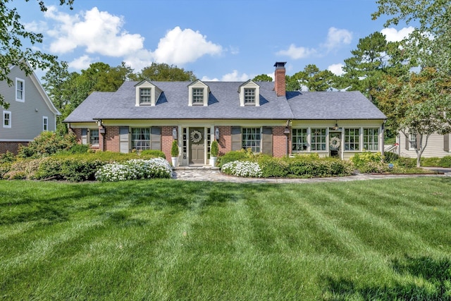 cape cod-style house featuring a front yard