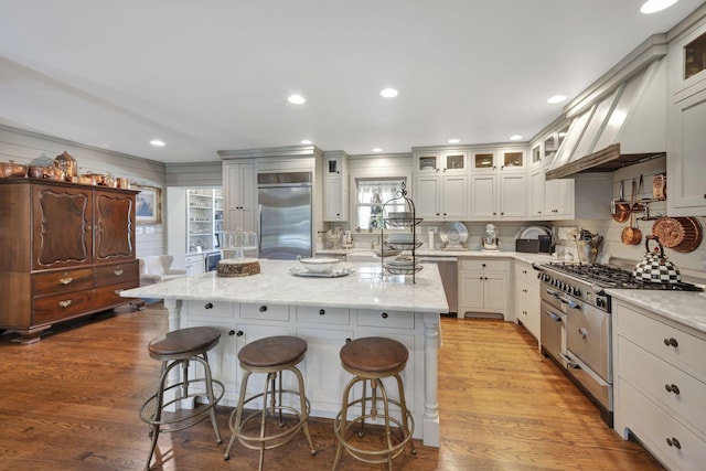 kitchen featuring a breakfast bar, a kitchen island, light wood-type flooring, and appliances with stainless steel finishes