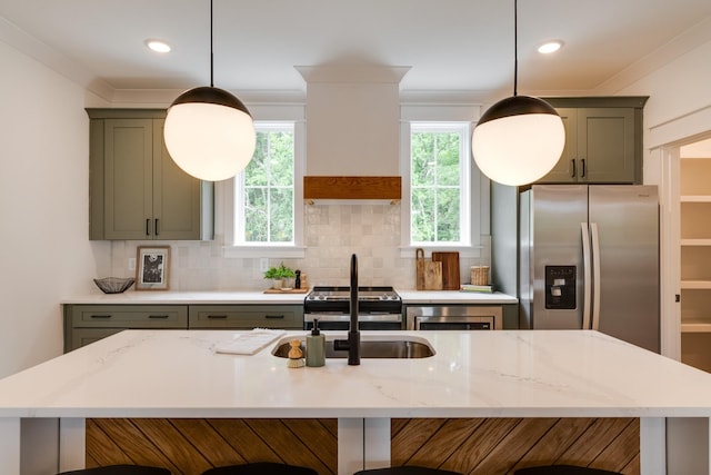 kitchen with light stone countertops, hanging light fixtures, crown molding, decorative backsplash, and appliances with stainless steel finishes