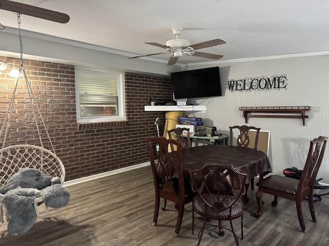 dining space with ceiling fan, dark hardwood / wood-style flooring, brick wall, and ornamental molding