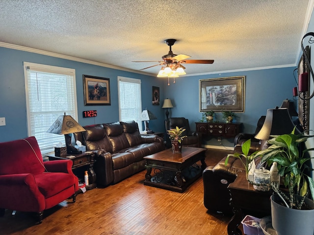 living room featuring ceiling fan, wood-type flooring, a textured ceiling, and ornamental molding