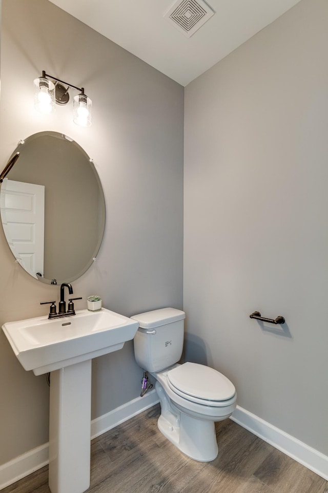 bathroom with hardwood / wood-style floors and toilet