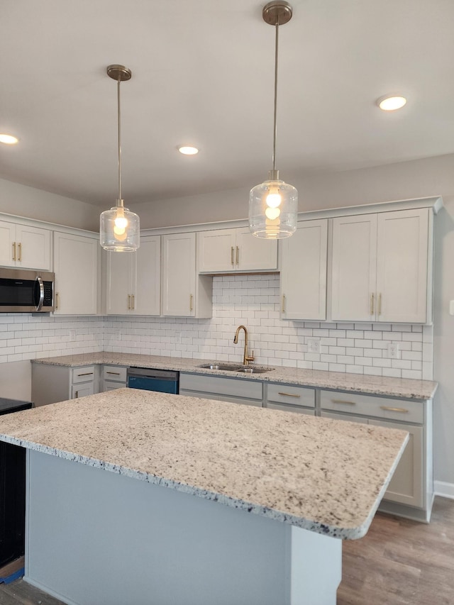 kitchen with white cabinetry, sink, decorative light fixtures, and dishwasher