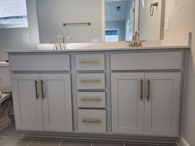 bathroom with tile patterned flooring, vanity, and toilet