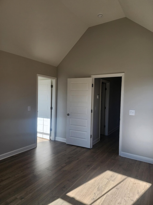 unfurnished room with lofted ceiling and dark hardwood / wood-style floors