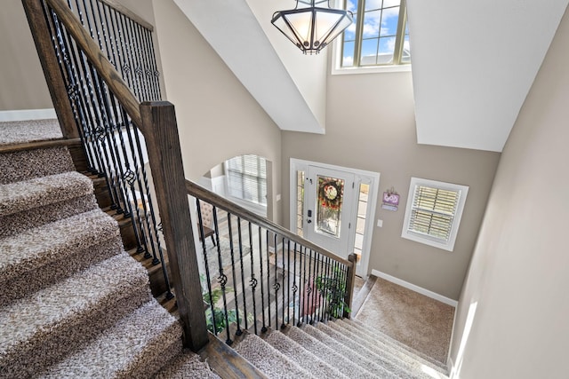 stairway featuring carpet and a chandelier