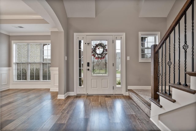 entryway featuring ornamental molding, a healthy amount of sunlight, and wood-type flooring